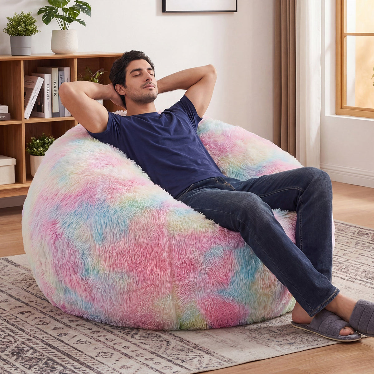 A man is lying comfortably on the Giant Rainbow Plush Sofa.