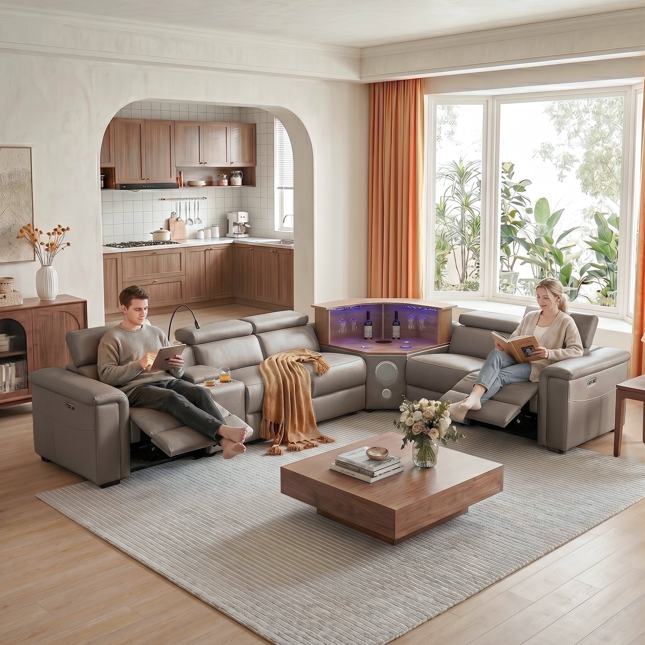 A couple is sitting on a khaki power recliner sofa set in the living room, using adjustable footrests to watch a tablet and read a book.
